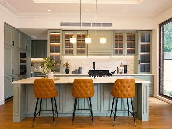 Modern brass linear chandelier suspended above kitchen island providing warm ambient lighting at Tinana Street, Haberfield