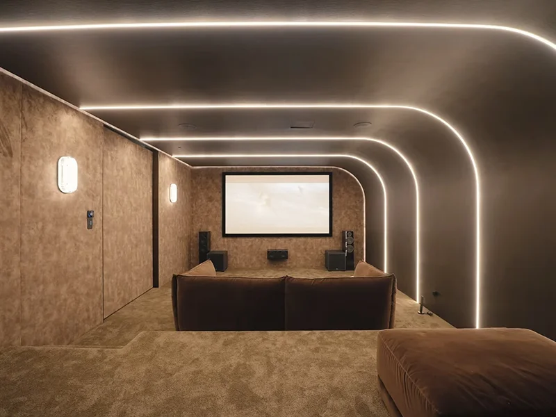 LED strip lighting installed along ceiling and walls in modern home cinema room at Sirius Avenue, Mosman