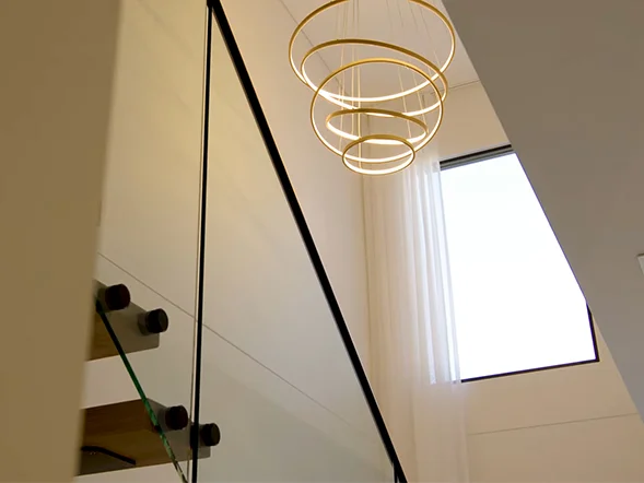 Modern LED chandelier with circular rings installed in stairwell void at York Avenue, Five Dock