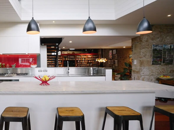 Black pendant lights installed above kitchen island providing focused task lighting at Balmain