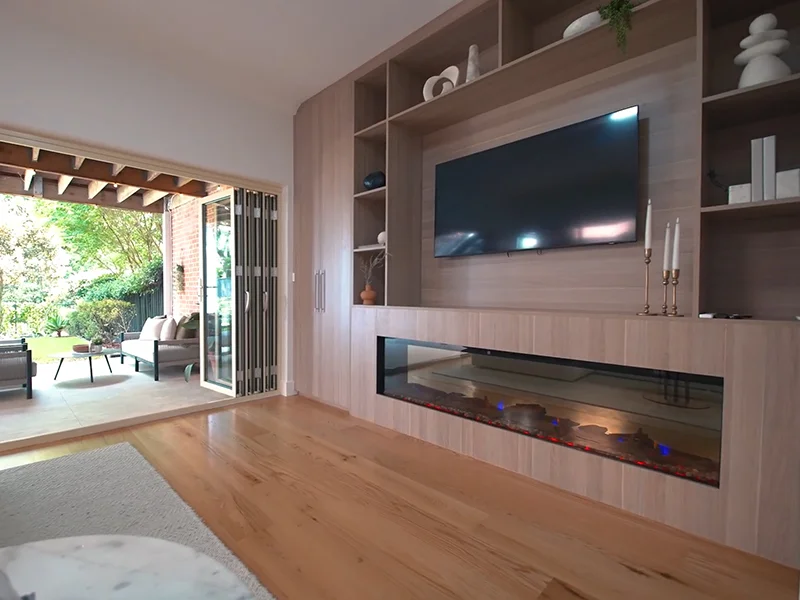Wall-mounted television installed above modern electric fireplace in custom living room cabinet at Market Street, Naremburn
