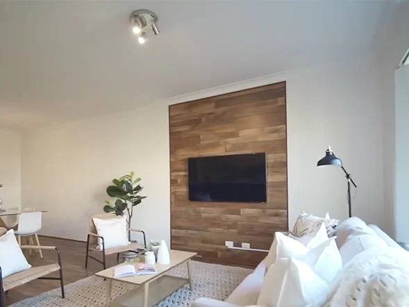 Wall-mounted TV installed on timber feature wall in living room at Banksia Street, Botany