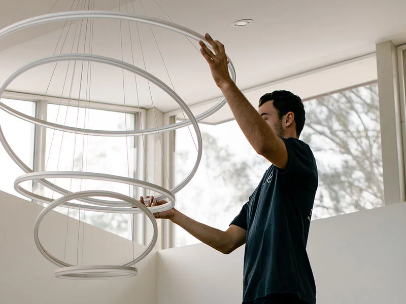 Calibre Connect electrician installing modern circular LED pendant chandelier in residential home
