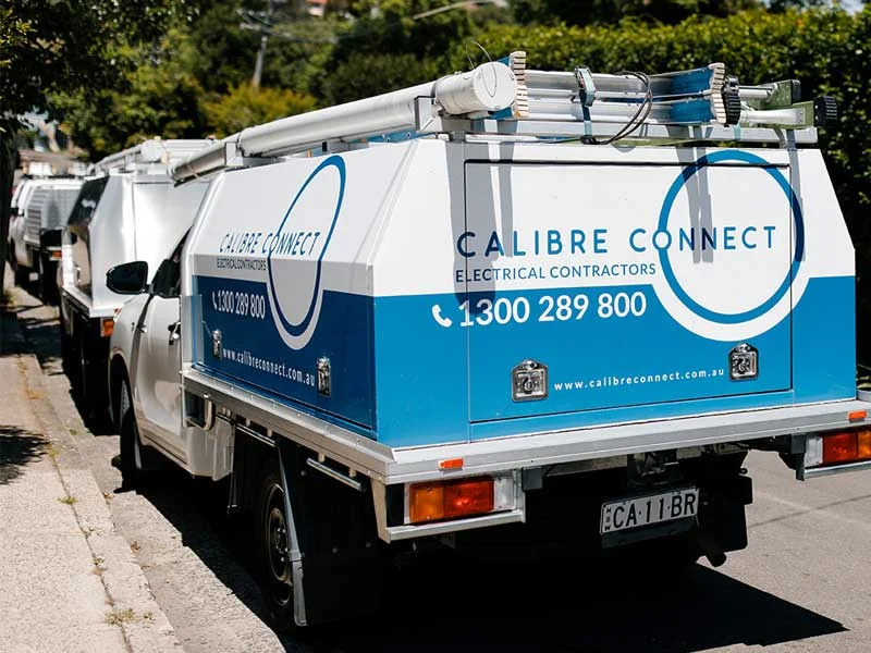 Fully equipped Calibre Connect electrician work vehicles parked on a residential Sydney street, ready to provide prompt, on-time electrical services