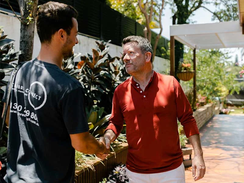 Calibre Connect electrician shaking hands with a homeowner in Sydney after completing an electrical service visit