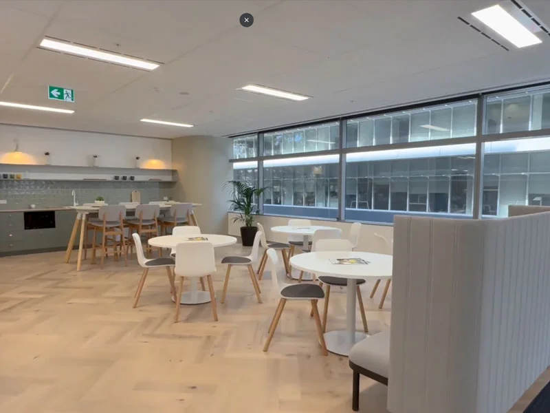 Commercial office space with LED ceiling panel lighting installation in breakout and kitchenette area