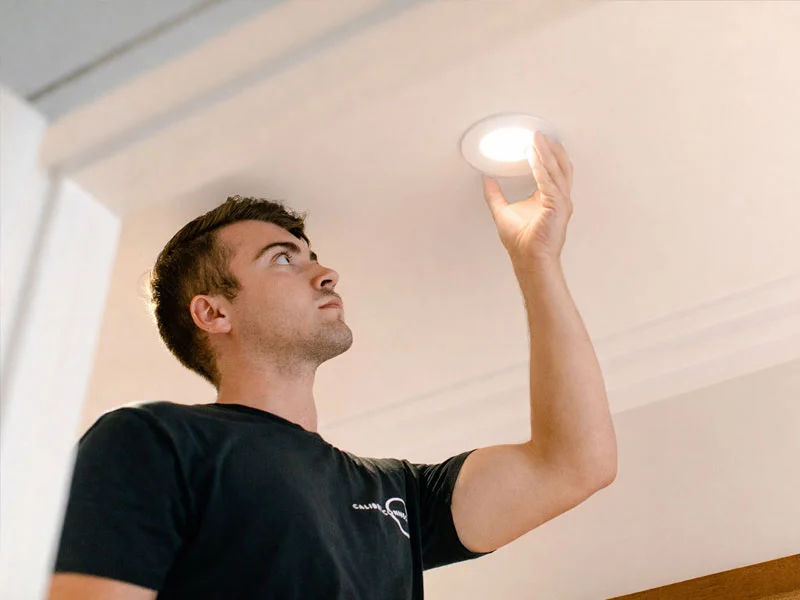 Calibre Connect electrician installing recessed LED downlight in ceiling during lighting upgrade