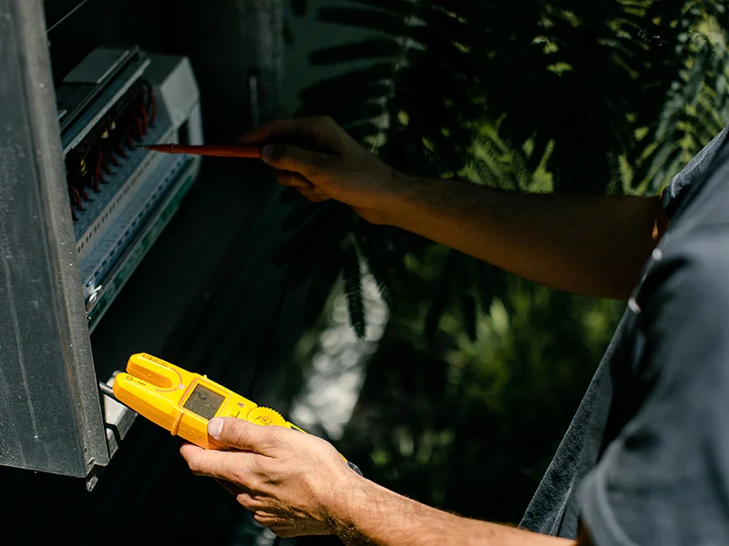 Calibre Connect electrician using a voltage tester during electrical safety checks at a Sydney property