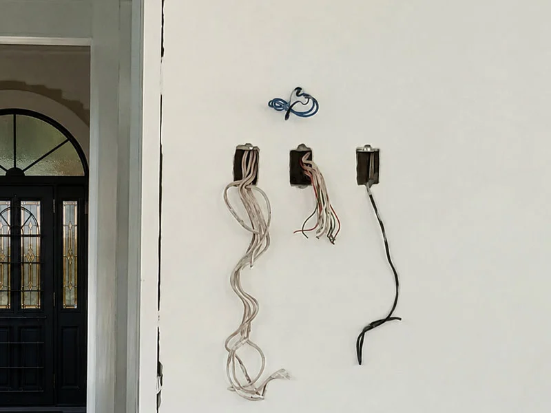 Pre-wired Cat 6 data and low-voltage power cables inside flush wall brackets ready for intercom and lighting control installation.