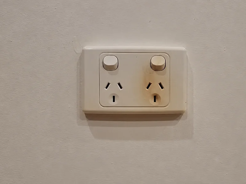 Burnt power outlet showing an electrical warning sign that needs an emergency electrician in Sydney