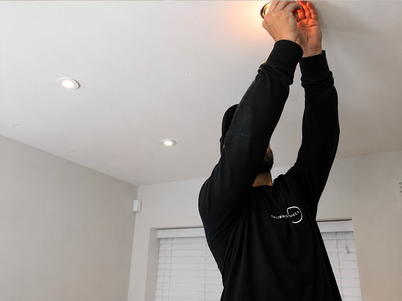 Licensed electrician performing final inspection of LED downlight installation in Sydney property