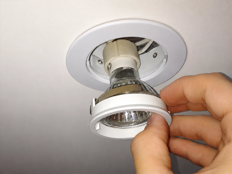 Old halogen downlight being upgraded to LED lighting in a Sydney property