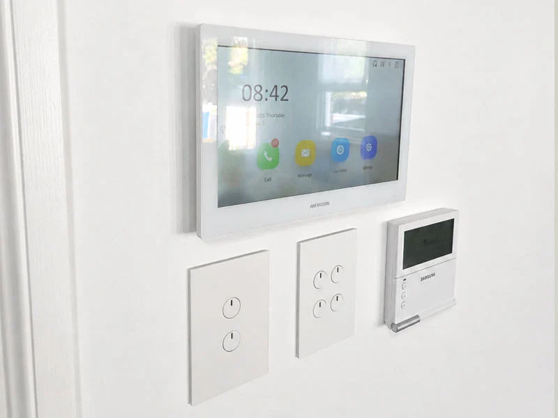 Angled view of a finished Hikvision 7-inch indoor video intercom monitor seamlessly integrated into a newly painted wall.
