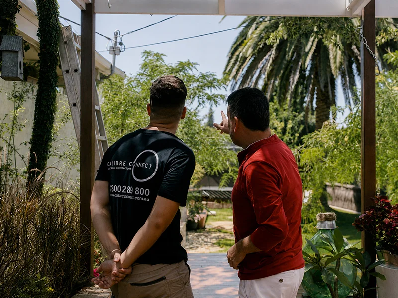 Level 2 electrician assessing overhead service lines with a Sydney homeowner