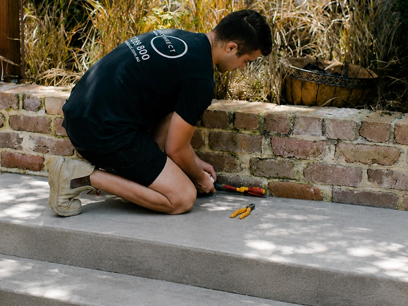 Electrician installing pathway and step lighting along an outdoor walkway in Sydney