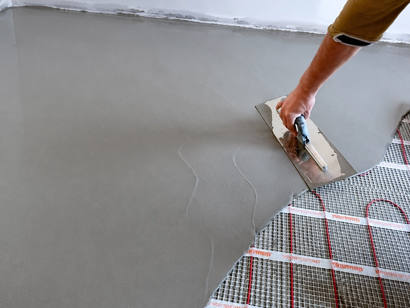 Electric underfloor heating system being coordinated with waterproofing and floor levelling before tiling in Sydney