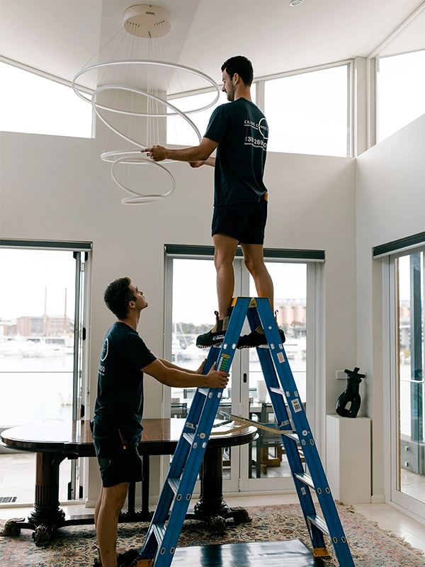 Calibre Connect electricians installing a large feature pendant light in a Sydney home